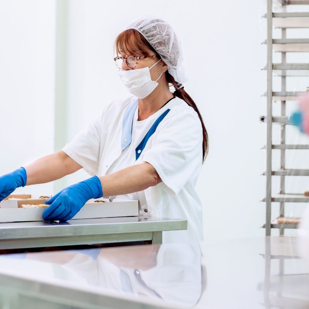 Profesional manipulando alimentos frescos en una cocina, representando el Curso de Manipulador de Alimentos con certificación oficial